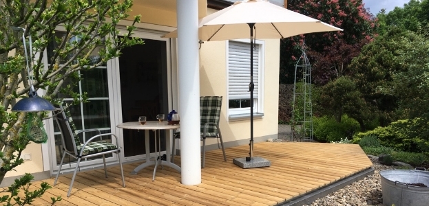 Eine Terrasse im Außenbereich, welche mit Holzlatten konstruiert wurde